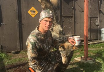 Hunter With Hunted Timber Wolf