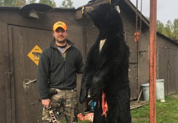 Man With Crossbow And Black Bear